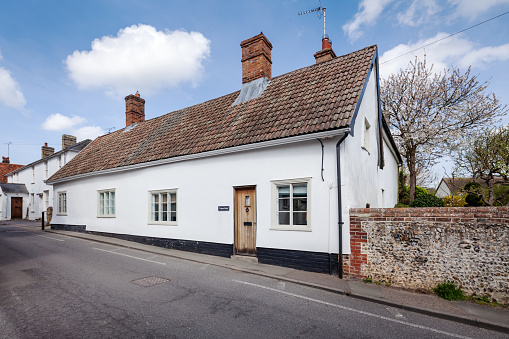 Great Chesterford, Essex - April 3 2017 - White rendered roadside english cottage with traditional pan tiled sloping roof.