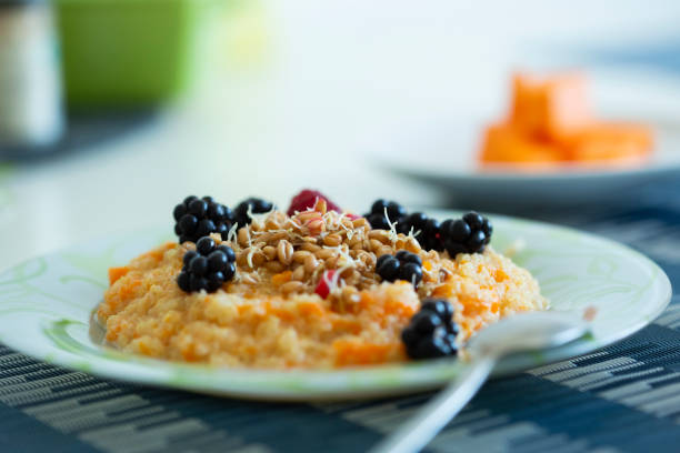 Cup of freshly brewed pumpkin porridge with berries. healthy food idea stock photo