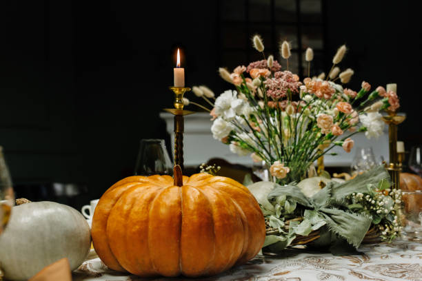 décoration et service de la table de fête avec décor d’automne, bougies et fleurs et citrouilles et plats. - feast day abundance vegetable food photos et images de collection