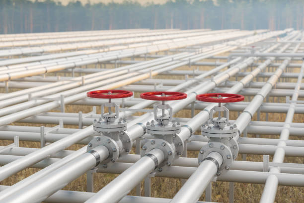 oil, gas or water transportation with pipe line valves on soil with defocused background - valve chemical plant oil industry imagens e fotografias de stock