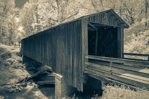 A covered wooden bridge in the forest.
