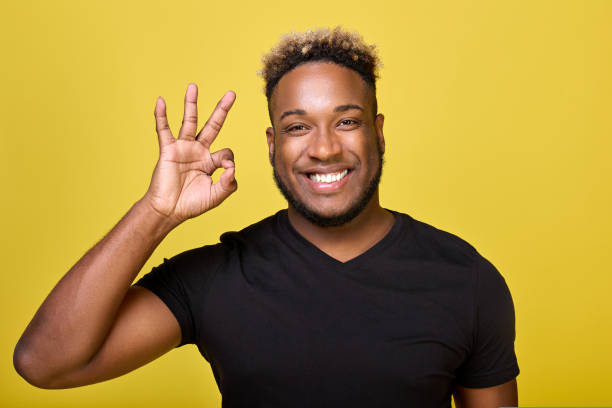 istock Dark-skinned smiling man makes a sign ok with his fingers 1434707332