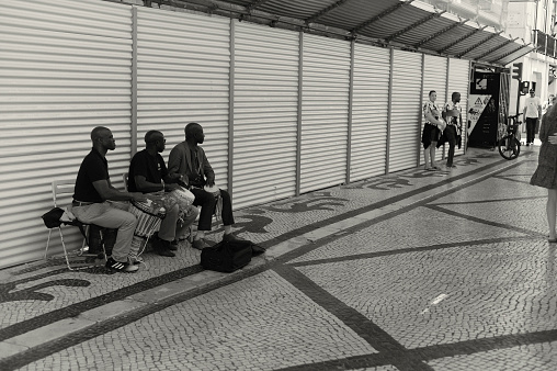 Lisbon, Portugal - July 2, 2022: African street musicians perform at the Rua Augusta street in Lisbon downtown.