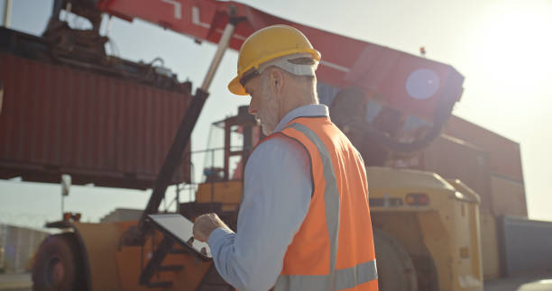 Logistics, container and tablet with man in shipping port with forklift for global delivery, cargo and supply chain industry. Export, freight and checklist with employee working on distribution stock photo