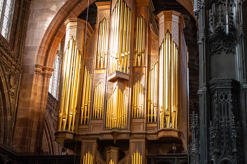 Salzburg - Salzburg - Austria - 06-17-2021: A choir organ in the Salzburg Cathedral, positioned in a corner with numerous pipes and a black railing, surrounded by balconies and paintings.