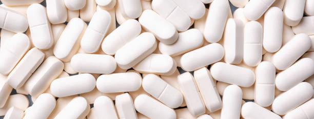 medicine background from bunch white pills, macro. drug production backdrop. - pill imagens e fotografias de stock