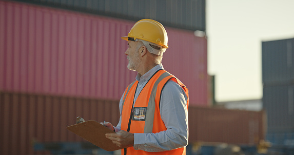 Logistics stock, clipboard writing and man in shipping yard, retail factory dock or industrial plant. Industry manager, worker and leadership with paper, cargo container or manufacturing supply chain