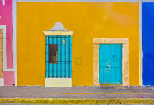 Yellow, blue, pink walls with turquoise windows and doors for this colonial style building in Campeche, Mexico.