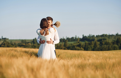 Couple just married. Together on the majestic agricultural field at sunny day.