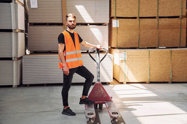 istock Trolley platform. Storage worker is in the warehouse with bunch of products 1434725701