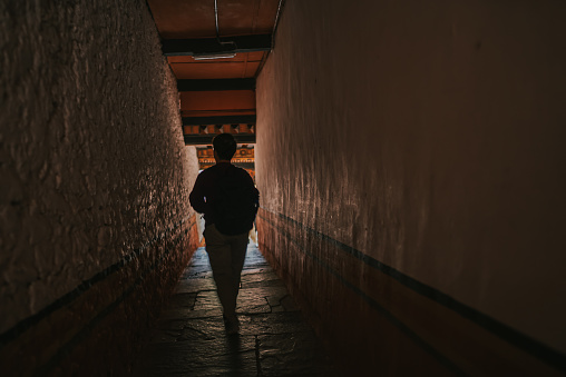 Rear View solo female traveller walking in corridor of Punakha Dzong