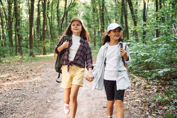 istock Walking forward. Two girls is in the forest having a leisure activity, discovering new places 1434729776