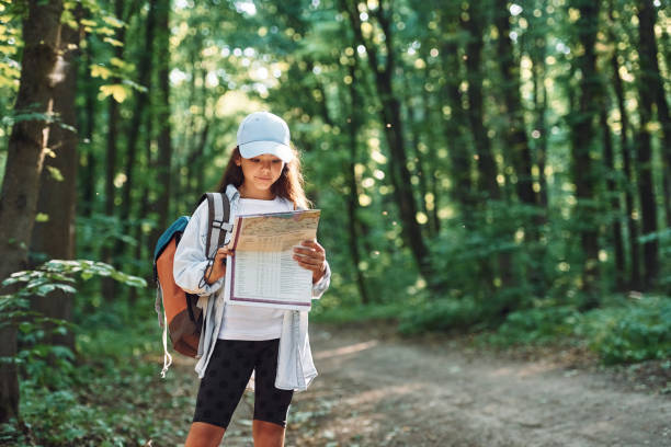 マップを使用する。女の子は新しい場所を発見する夏の昼間に森の中にいます - free standing audio ストックフォトと画像