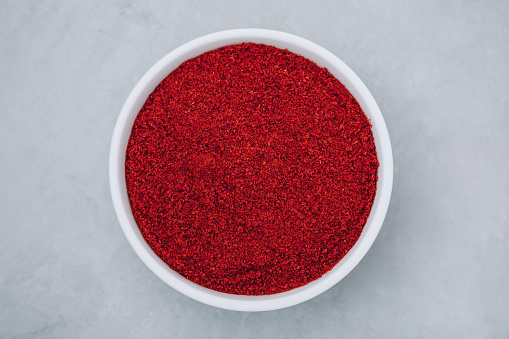 Chilli powder. Smoked chilli paprika. Red chilli powder paprika in bowl on gray stone background. Top view with copy space.