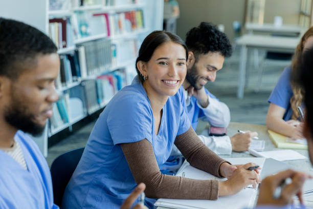 gli altri studenti sorridono mentre due compagni di classe discutono le idee - paramedico foto e immagini stock