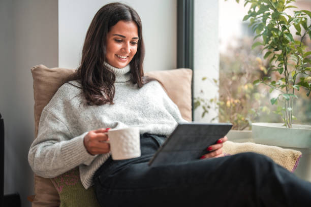 istock Smiling Young Caucasian Female Using A Digital Tablet On A Cozy Morning At Home 1434731727