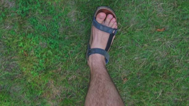 istock Caucasian Man Wearing Sport Leather Sandals Walking on Grass Field 1434732300