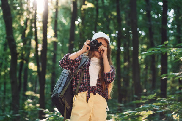 istock Young photographer with camera. Girl is in the forest at summer day time discovering new places 1434732490