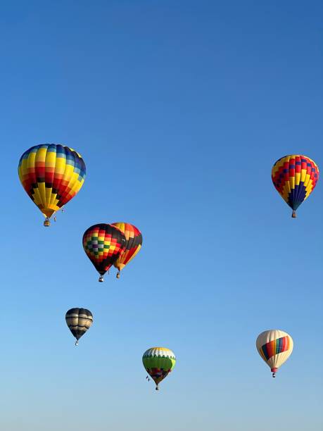 istock Vertical shot of colorful hot air balloons in a blue sky 1434732871
