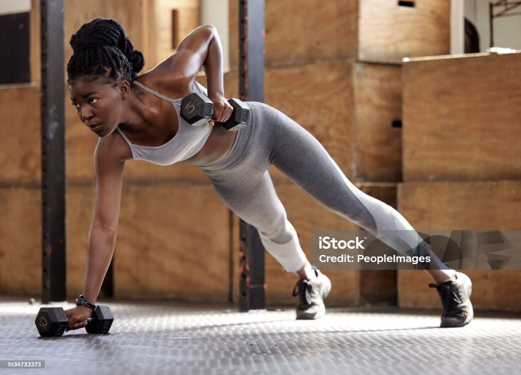 Strong woman doing fitness training for exercise at gym, weights for cardio workout and motivation for lifestyle and healthy body. African athlete doing sports on floor with equipment for wellness Woman doing fitness training for exercise at gym, weights for cardio workout and motivation for strong and healthy body at health club. African athlete doing pilates with equipment for wellness Women Stock Photo
