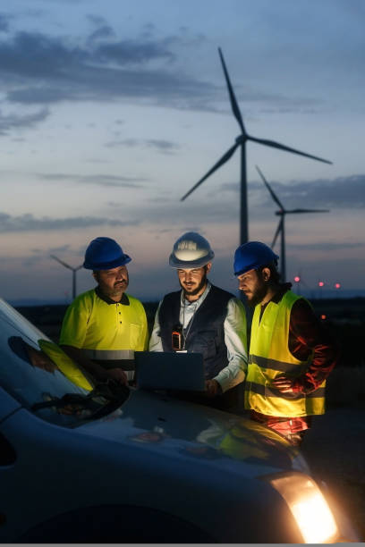 istock Team of technicians and engineer working in wind turbine farm at night, planing renewable energy ecology project 1434738052