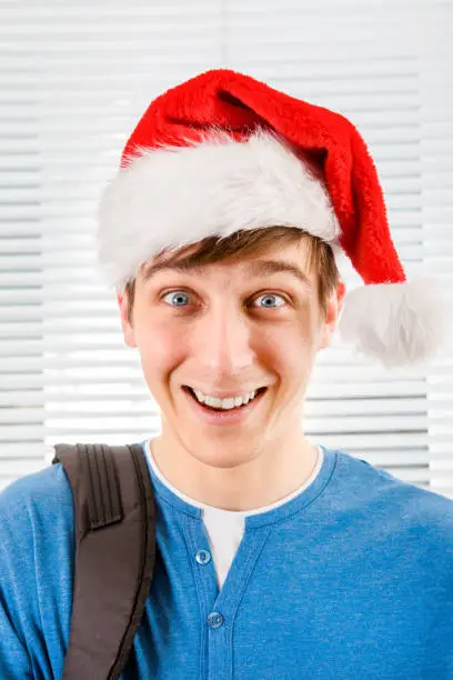 Happy Young Man in Santa Hat on the Jalousie Background