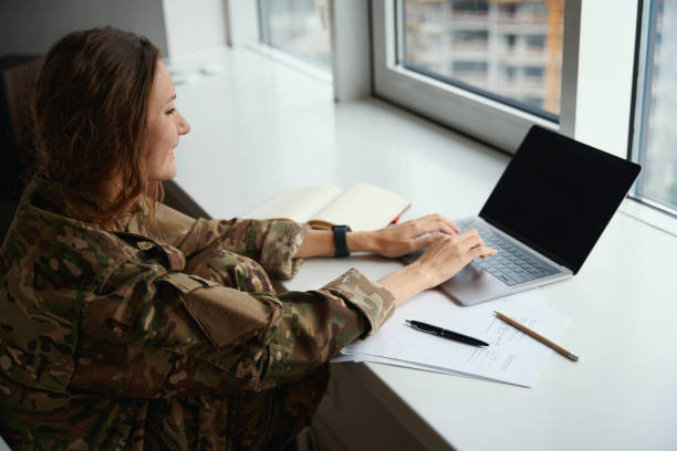 istock Military woman typing on laptop keyboard and making notes 1434739125