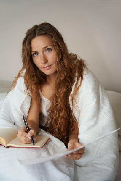 istock Woman is busy working with texts and documents in bed 1434739255