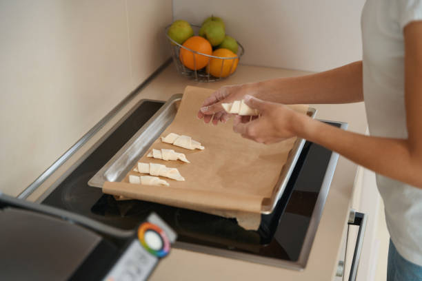 istock Woman is laying out several croissants on baking parchment 1434739272