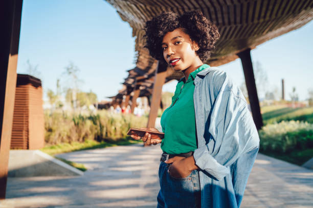 istock Pleased young black lady surfing Internet from park 1434742678