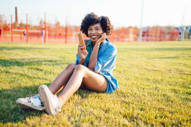 istock Smiling woman browsing cellphone in sunny day 1434742733