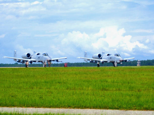 A-10C Thunderbolt IIs Prepare to Take-Off at Moody Air Force Base, Georgia (USA) Valdosta, Georgia, USA - July 22, 2014: Two A-10C Thunderbolt II attack jets prepare to take off from Moody Air Force Base on a hot, summer day as maintenance personnel check over the jets. a10 warthog stock pictures, royalty-free photos & images