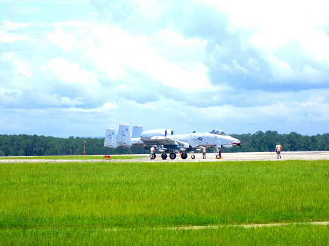 Valdosta, Georgia, USA - July 22, 2014: Two A-10C Thunderbolt II fighter jets prepare to take off from Moody Air Force Base on a hot, summer day as maintenance personnel check over the aircraft.