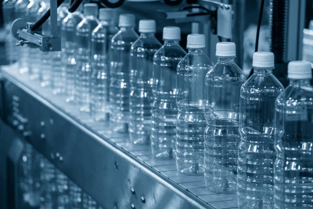 充填工程用コンベヤベルト上の空の飲料水ボトルのクローズアップシーン。 - bottling plant bottle filling production line ストックフォトと画像