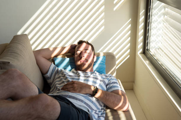 istock Relaxed man sleeping on a sofa close to window. 1434755442
