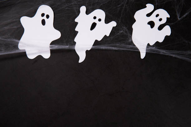 istock Halloween Decoration and horror concept - spider web with ghosts over black background 1434759455