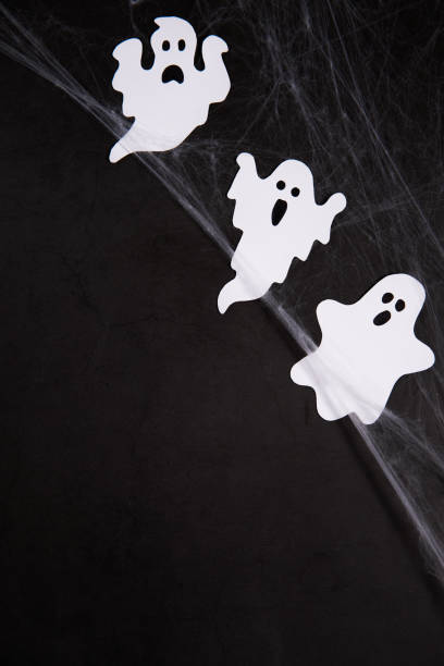 istock Halloween Decoration and horror concept - spider web with ghosts over black background 1434759466