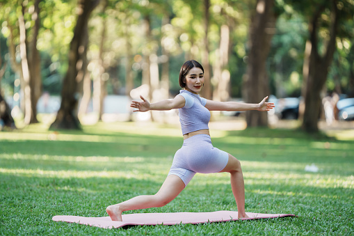 Beautiful young asian woman yoga exercising in the park.