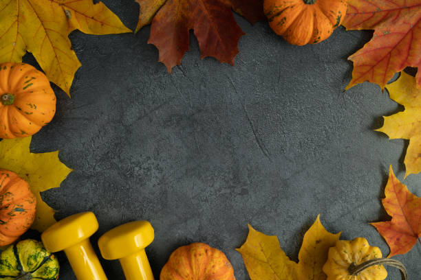 istock Autumn flat lay gym composition frame, with dumbbells, pumpkins on fall leaves and copy space. 1434763299