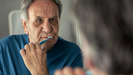 Old man brushing his teeth