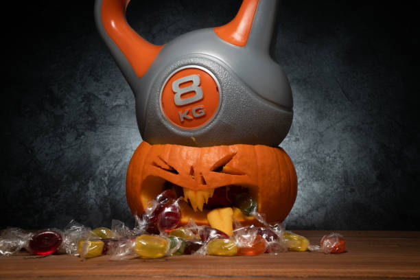 istock Heavy gym kettlebell crushing carved Halloween pumpkin. 1434763574
