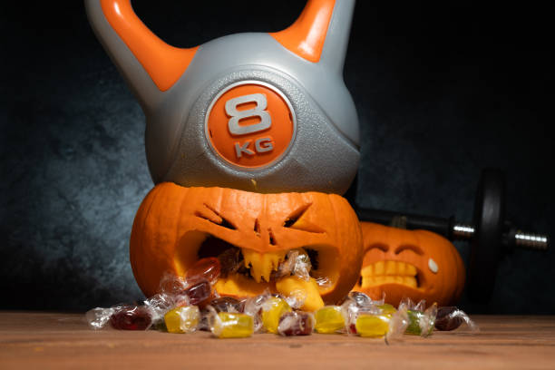 istock Heavy gym kettlebell crushing carved Halloween pumpkin. 1434763582