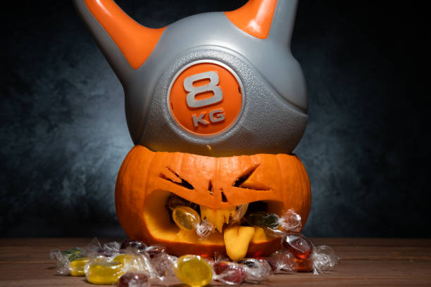 istock Heavy gym kettlebell crushing carved Halloween pumpkin. 1434763614
