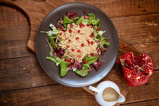 Vegan salad with millet and pomegranate, tahini dressing