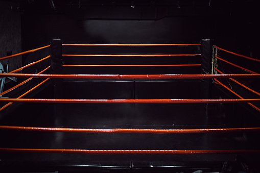 Boxing ring in dark gym.