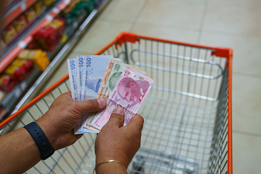 Man counting money in a supermarket, close up