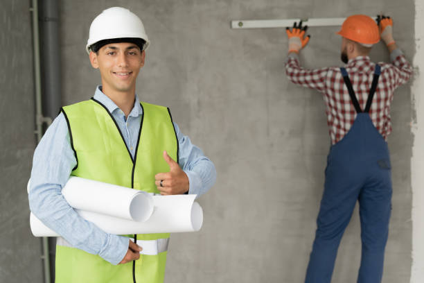 istock Home renovation. Happy engineer or architect showing a symbol of joy and a builder with a level in the background 1434777183