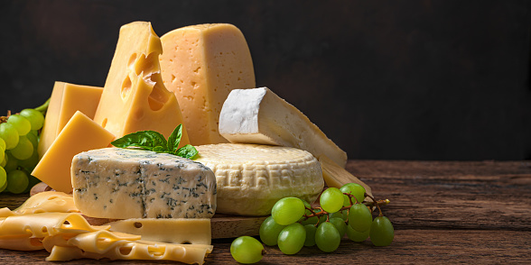 Different types of sarah on a wooden background. Assortment of cheeses. Side view.