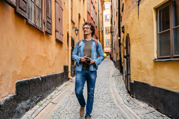 junger tourist geht durch die gasse - stadsholmen stock-fotos und bilder