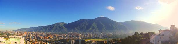 istock Panoramic shot of dense buildings and a mountain range under the blue sky 1434779349